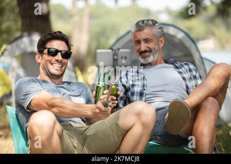 gruppo di amici in campagna in campeggio facendo selfie Foto Stock