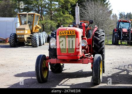 Trattori Classic, 1960s attrezzatura David Brown e Valmet 1502, parcheggiati in un cortile in un giorno di primavera. Foto Stock