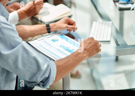 immagine ritagliata di un uomo d'affari che guarda un grafico finanziario. Foto Stock
