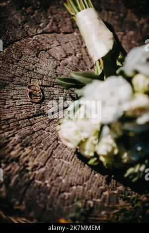 Due anelli per matrimoni sul pavimento con anelli per matrimoni a contrasto sul pavimento, sul piano terra, al pianoforte, a portata di mano Foto Stock