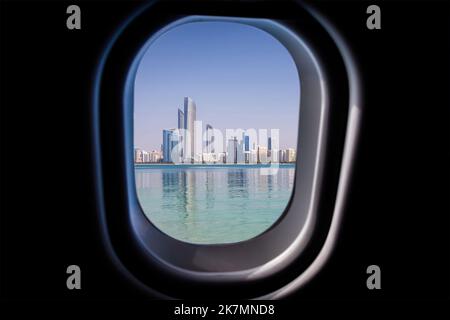 Vista attraverso una finestra in jet plane alta sul cielo blu degli Emirati Arabi Uniti di Abu Dhabi Foto Stock