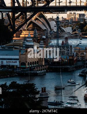 La famosa Sydney Opera House e il Luna Park si illuminano dall'alba Foto Stock