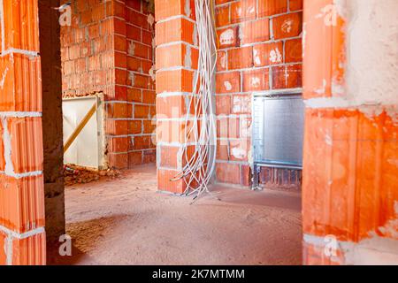 Fascio di vari cavi appesi al soffitto, nuovo sistema di distribuzione vuoto montato per il riscaldamento centrale in un edificio residenziale sotto la con Foto Stock