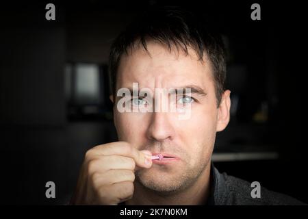 tenere la bocca chiusa concetto. L'uomo triste chiude la bocca. Silenzio. Giovane ragazzo carino cerca di aprire la bocca chiusa. Foto Stock
