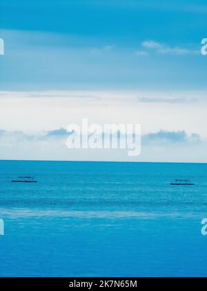 Un cielo blu nel pomeriggio sopra il mare blu profondo Foto Stock