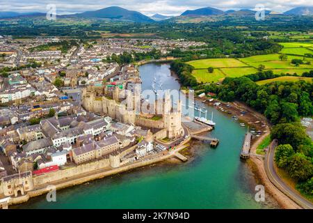 Veduta aerea di Caernarfon, storica città reale fortificata e porto di Gwynedd, Galles del Nord, Regno Unito, famosa per il suo grande castello medievale Foto Stock