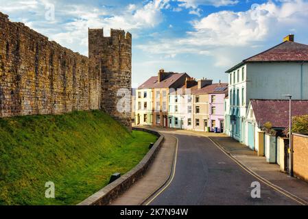 Case colorate e mura della città nella storica città vecchia fortificata di Caernarfon, Gwynedd, Galles del Nord, Regno Unito Foto Stock
