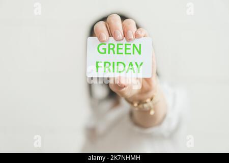Carta di credito con iscrizione VENERDÌ VERDE in mano femminile. Foto Stock