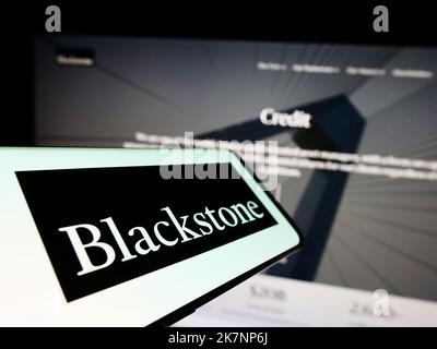 Cellulare con il logo della società americana di investimento Blackstone Inc. Sullo schermo di fronte al sito web aziendale. Messa a fuoco al centro a sinistra del display del telefono. Foto Stock