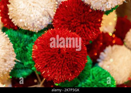 Grazioso Natale sfondo natalizio di Red Green e White Sparkly palle di pompon - alcuni a fuoco e alcuni sfocati e boke Foto Stock