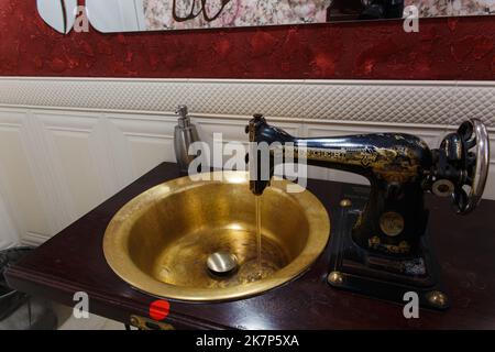 Grodno, Bielorussia - 13 ottobre 2017: Lavabo realizzato con una vecchia macchina da cucire Singer nel bar Faraday. L'acqua si accende automaticamente quando l'h Foto Stock