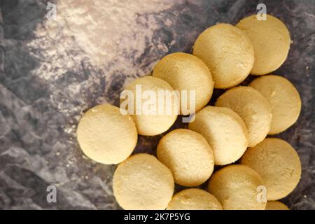 Biscotti fatti in casa appena sfornati su vassoio rack forno su fondo scuro piatto Foto Stock