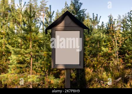 Vuoto segno bianco in natura, con alberi verdi sullo sfondo Foto Stock