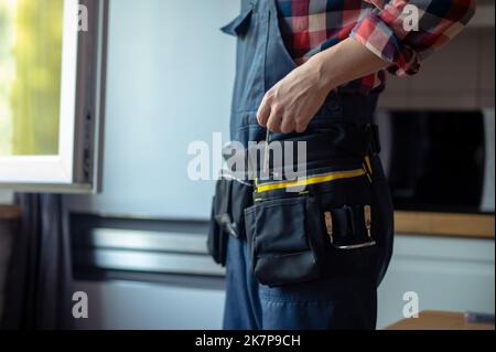 Riparatore specializzato che prepara per fissare una finestra della cucina Foto Stock