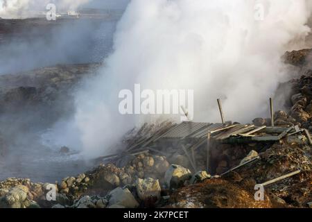 Sorgenti termali geotermiche di Gunnuhver con centrale di Svartsengi in lontananza, Reykjanes Peninula, Islanda Foto Stock