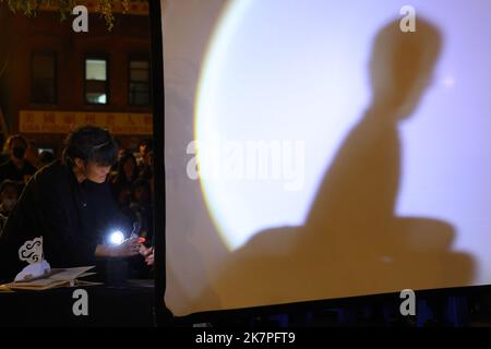 Puppeteer Spica Wobbe con burattini ombra al Manhattan Chinatown Night Market, 14 ottobre 2022. Foto Stock