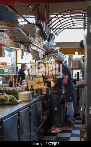 Baristi uomo e donna che indossano grembiuli che lavorano in un bancone in un bar all'interno. Concetto di servizio di preparazione del caffè per la preparazione del caffè per il barista Cafe. Cameriere che lavorano Foto Stock