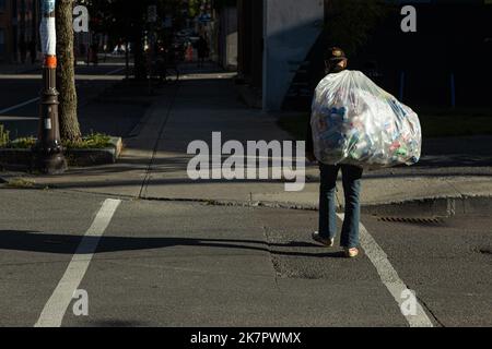 Un uomo cammina con una borsa piena di lattine e bottiglie rimborsabili nel quartiere della città di Quebec di St-Roch il 16 settembre 2022. Foto Stock