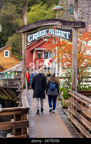 Coppia a piedi lungo il lungomare sulla storica Creek Street a Ketchikan, Alaska, USA Foto Stock