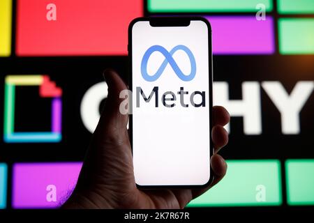 Il logo Meta è visto con il logo Ghiphy sullo sfondo in questa foto di illustrazione a Varsavia, Polonia, il 19 ottobre 2022. Società madre di Facebook Foto Stock