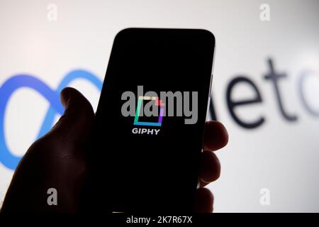 Il logo Giphy è visto su un dispositivo mobile con il logo Meta sullo sfondo in questa foto di illusione a Varsavia, Polonia, il 19 ottobre 2022. Faceb Foto Stock