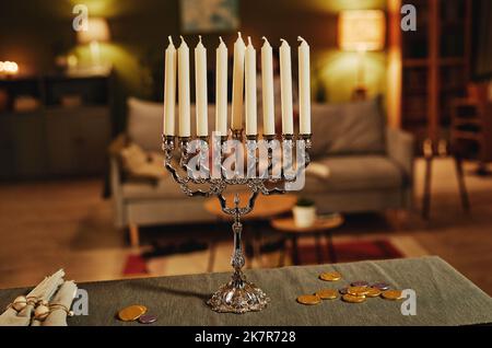 Immagine di sfondo di argento candela menorah in accogliente casa interna, spazio copia Foto Stock