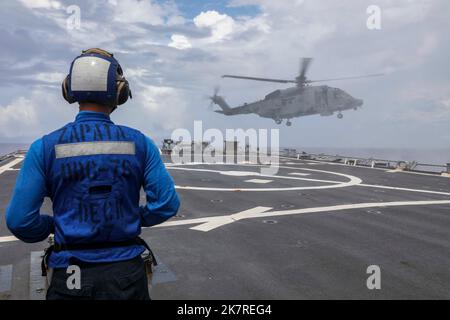 MAR CINESE MERIDIONALE (5 ottobre 2022) Un elicottero canadese Sikorsky CH-148 Cyclone attaccato alla Royal Canadian Navy Halifax-class fregate HMCS Winnipeg (FFH 338) si avvicina al ponte di volo a bordo del cacciatorpediniere di missili guidati di classe Burke USS Higgins (DDG 76) mentre conduce operazioni multilaterali nel Mar Cinese Meridionale, ottobre 5. Gli Stati Uniti, con la Japan Maritime Self Defense Force e la Royal Canadian Navy, stanno partecipando ad esercizi multilaterali nel Mar Cinese Meridionale a sostegno della presenza regionale della Royal Australian Navy. Esercizi come questo rassicurano i nostri alleati e p Foto Stock