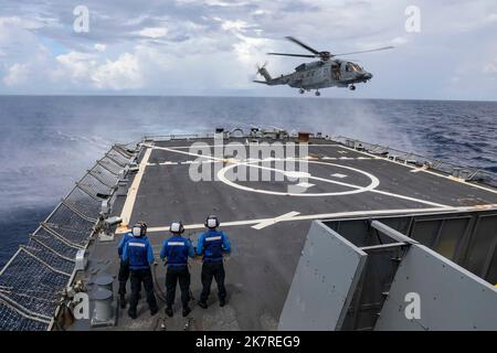 MAR CINESE MERIDIONALE (5 ottobre 2022) Un elicottero canadese Sikorsky CH-148 Cyclone attaccato alla Royal Canadian Navy Halifax-class fregate HMCS Winnipeg (FFH 338) si avvicina al ponte di volo a bordo del cacciatorpediniere di missili guidati di classe Burke USS Higgins (DDG 76) mentre conduce operazioni multilaterali nel Mar Cinese Meridionale, ottobre 5. Gli Stati Uniti, con la Japan Maritime Self Defense Force e la Royal Canadian Navy, stanno partecipando ad esercizi multilaterali nel Mar Cinese Meridionale a sostegno della presenza regionale della Royal Australian Navy. Esercizi come questo rassicurano i nostri alleati e p Foto Stock