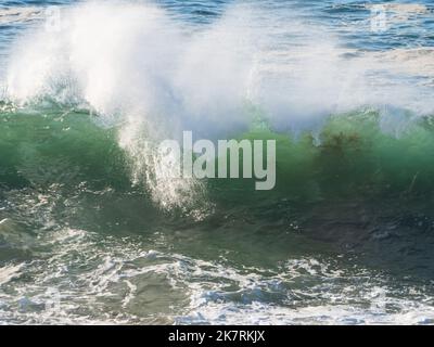 Primo piano di Un'onda verde vetrosa dell'Oceano Pacifico che spruzza acqua salata ovunque mentre rompe spruzzi e si schianta, Australia Foto Stock