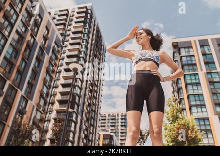 Ragazza sportiva ben costruita in abbigliamento sportivo che guarda sicuro Foto Stock