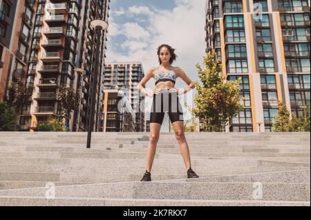 Ragazza sportiva ben costruita in abbigliamento sportivo che guarda sicuro Foto Stock