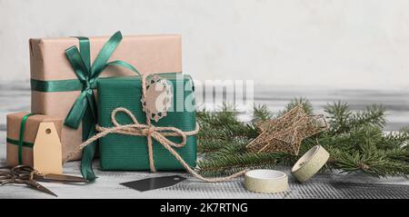 Belle scatole regalo per Natale con decorazioni su tavola di legno Foto Stock