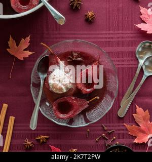 Vista dall'alto verso il basso delle pere al vino rosso in camicia con gelato alla vaniglia. Foto Stock