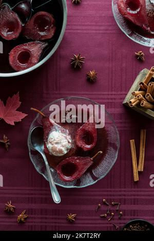 Un servizio di pere al vino rosso in camicia con gelato alla vaniglia. Foto Stock