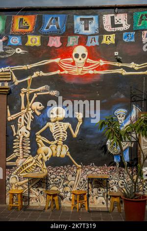 Molte case sono dipinte con murales colorati, qui con scheletri, nel Barrio de Jalatlaco, nella città di Oaxaca, Messico. Foto Stock