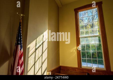 Bandiera americana, luce solare attraverso una finestra, in una storica chiesa presbiteriana a Bentonsport, Iowa, USA Foto Stock