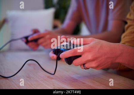 Mani di un giovane che tiene il controller durante il gioco video Foto Stock