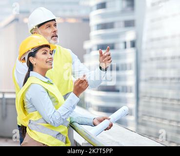 La città avrà un aspetto diverso una volta che sono stati fatti. due uomini d'affari che lavorano insieme in un cantiere. Foto Stock