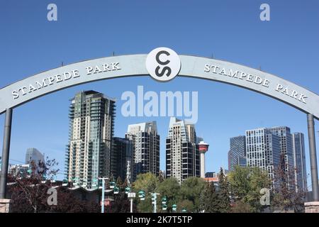 Un cartello per lo Stampede Park con gli edifici del centro sullo sfondo a Calgary, Alberta, Canada Foto Stock