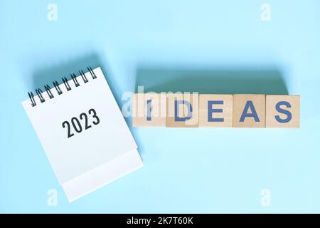 Nuovo anno 2023 nuovo concetto di idee commerciali. Calendario da tavolo piatto su sfondo blu. Foto Stock