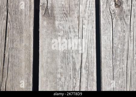 Pavimentazione in legno invecchiato, parete con nodi, crepe e sabbia. Foto Stock