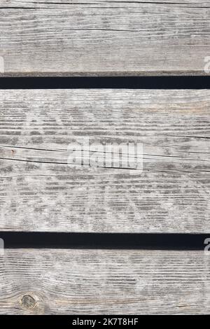 Pavimentazione in legno invecchiato, parete con nodi, crepe e sabbia. Scatto verticale. Foto Stock