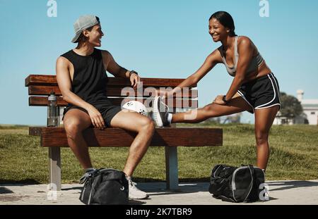 Esercizio, stretching e sport coppia rilassarsi nel parco, parlando mentre si preparano per lo sport, l'allenamento e il benessere. Atletica, donna e uomo Foto Stock