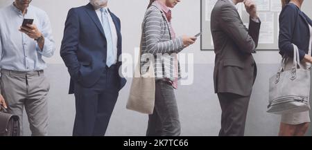 Diverse persone in piedi e in attesa in linea, servizi e concetto di reclutamento Foto Stock