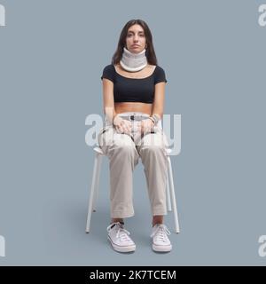 Paziente ferito che indossa una tracolla e che siede su una sedia, assistenza sanitaria e concetto di medicina Foto Stock