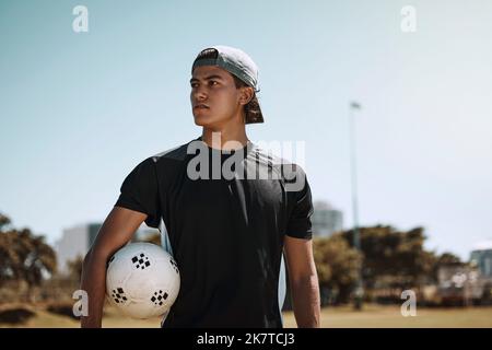 Calcio, sport e allenamento con un atleta che tiene una palla su un campo o campo da prato prima di una partita. Fitness, calcio ed esercizio con un maschio Foto Stock