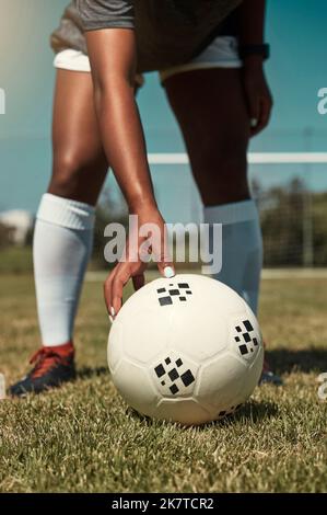 Mano, piazzamento e pallone da calcio sul campo per calcio libero, rigore o gol nel gioco, allenamento o partita. Donna, calcio e erba all'aperto in estate per Foto Stock