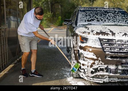 Ama la sua auto. Uomo lavaggio auto. Foto Stock