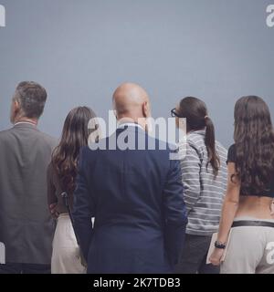 Gruppo di persone diverse in piedi e guardando avanti, vista posteriore Foto Stock