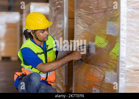 inventario del carico lavoratore indiano maschio di lavoro codici a barre scansione prodotti di controllo spedizione merci Foto Stock